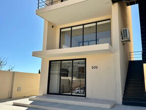 A modern two-story building with a flat facade, large windows, and a visible number '101' on the side. - 2BR Vistana Estates Townhome 5min to Downtown Cabo (El Tezal, Cabo San Lucas)