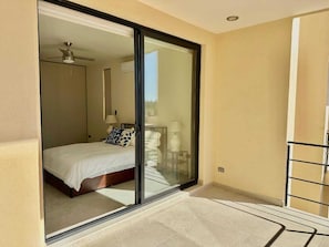 A bedroom with a bed, a ceiling fan, and a sliding glass door leading to a balcony. - 2BR Vistana Estates Townhome 5min to Downtown Cabo (El Tezal, Cabo San Lucas)