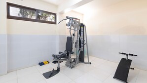 Una palestra con attrezzature per esercizi, una panca e manubri.