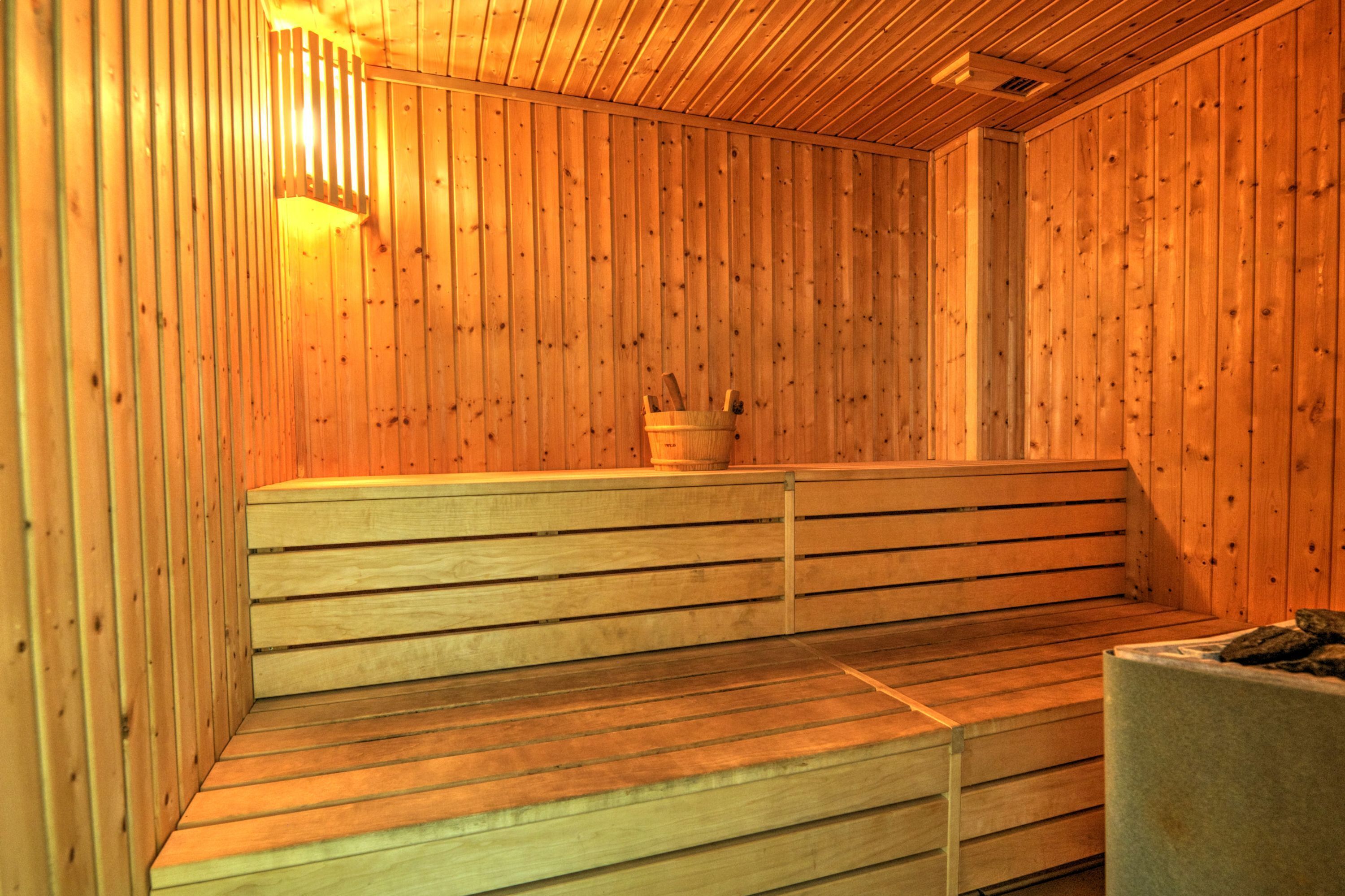 A sauna with wooden benches and a bucket.