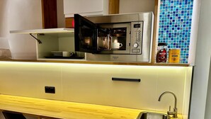 Una cocina compacta equipada con microondas, pileta y refrigerador.