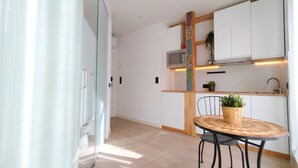 Una cocina moderna con armarios blancos, un microondas y una encimera de madera.