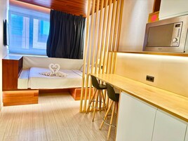 A compact room with a bed, a desk, and a TV.