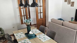 Un comedor con una mesa de madera, sillas y un sofá.