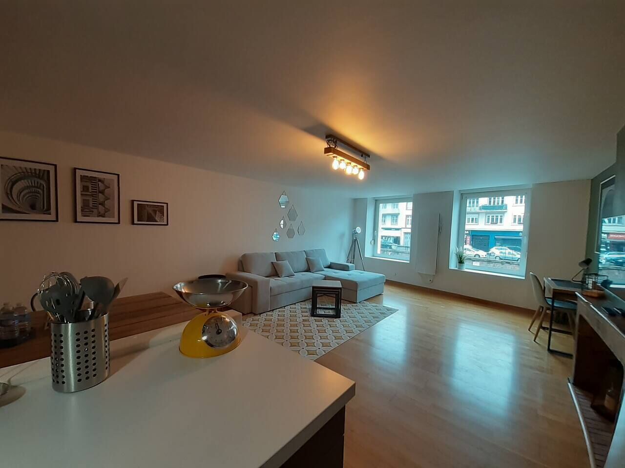 Un salon moderne comprenant un canapé, une table à manger et un coin cuisine.