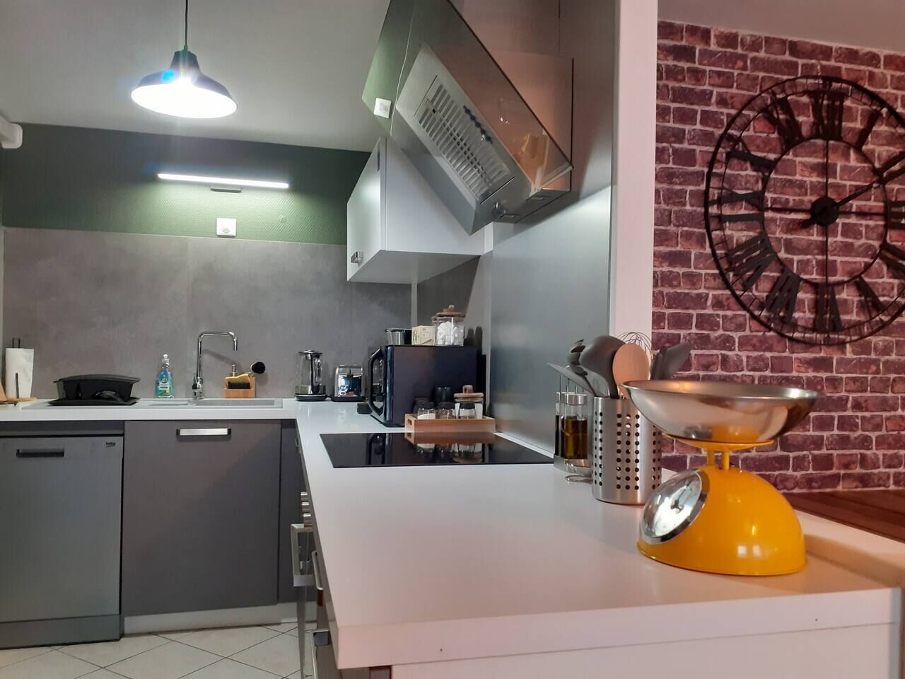 A modern kitchen with a built-in oven, a coffee machine, and a yellow scale on the counter.