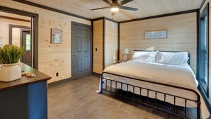 Un dormitorio con cama, ventilador de techo, ventana y puerta.