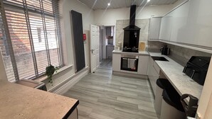 Una cocina moderna con horno empotrado, campana extractora negra y encimera con lavaplatos.