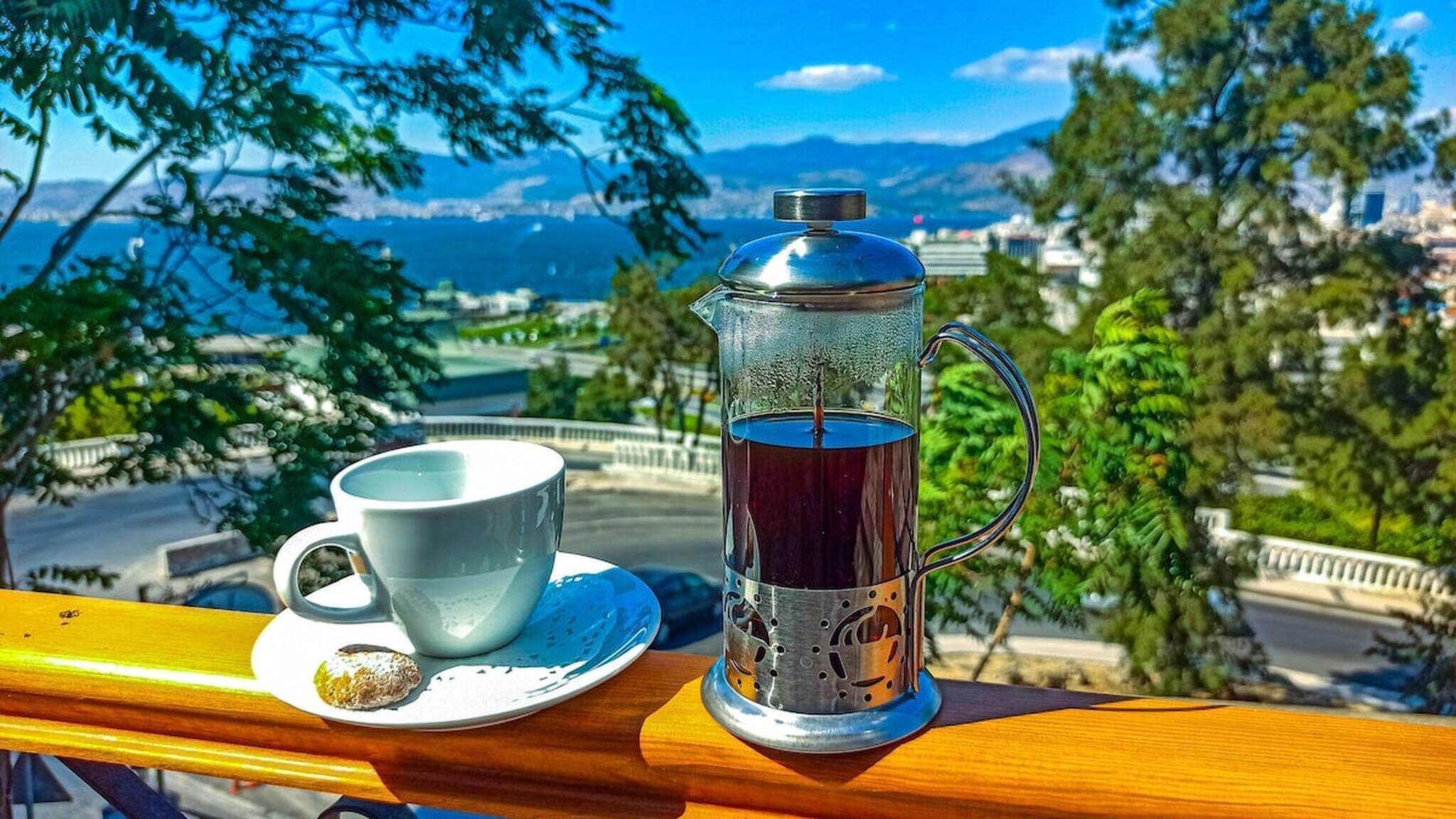Eine Kaffeekanne und Tasse auf einem Balkon mit Blick auf eine schöne Aussicht.