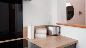 Een moderne keuken met een inbouwoven, een broodrooster en een doos met de tekst 'SUCRE THE INFUSION'.