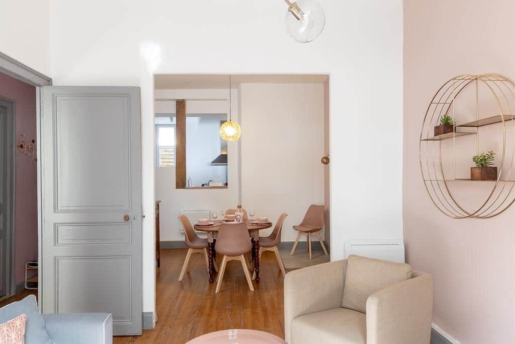 En modern inredning med ett matområde, en soffa och en vägghylla.