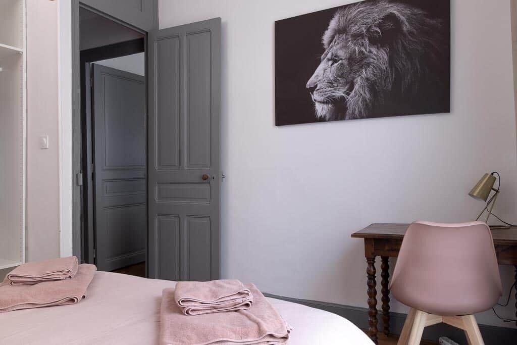 Ein Schlafzimmer mit einem Bett, einem Schreibtisch mit Stuhl und einer Tür zu einem anderen Raum.