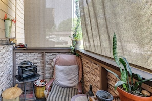 A cozy corner with a small table, a chair, a potted plant, and a window with a view. - Walk to Parks & Dining! Lakewood Condo w/ Balcony (Lakewood)