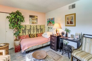 A bedroom with a bed, a dresser, a desk, a chair, a lamp, a potted plant, and artwork on the walls. - Walk to Parks & Dining! Lakewood Condo w/ Balcony (Lakewood)