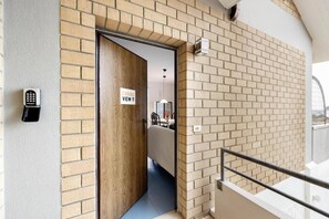 Ein Hotel Eingang mit einer Ziegelwand, einer Holztür und einem Schild mit der Aufschrift 'CASOLI VIEW 11'.