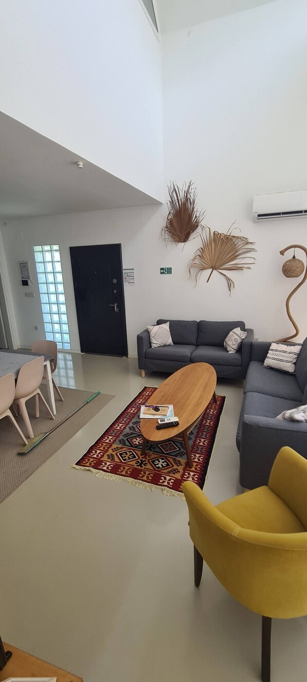 A modern living room with a sofa set, a coffee table, and decorative wall art.