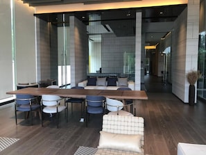 A modern interior with a long dining table, chairs, and a sofa. - 2 Bed Room Luxury I Stunning Sea View & Bath Tub (Muang Pattaya)