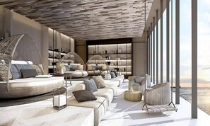 A modern interior with a large window, a curved seating area, and a bookshelf. - 2 Bed Room Luxury I Stunning Sea View & Bath Tub (Muang Pattaya)