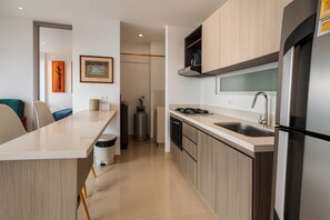 Cafetera o tetera, frigorífico, placa de cocina y utensilios de cocina
