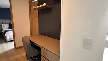 Un dormitorio moderno con cama, escritorio y silla.