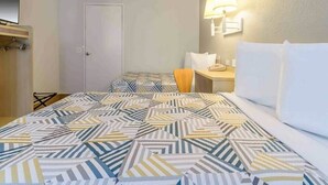 A hotel room with a bed, a bedside table with a lamp, a chair, and a wardrobe. - 2 Full Beds|Renovated,Mini Fridge (Hayward)