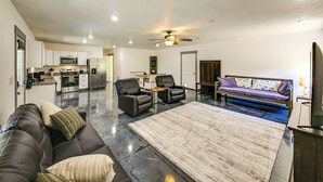 A modern living room with a sofa, two chairs, a coffee table, a fireplace, and a kitchen in the background. - Bring Your Boat! Updated Cabin in Priest River (Priest River)