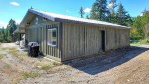 A small, single-story wooden building with a gabled roof, a window, and a door. - Bring Your Boat! Updated Cabin in Priest River (Priest River)