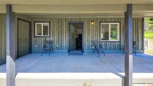 A covered porch with a door, two chairs, and a rug. - Bring Your Boat! Updated Cabin in Priest River (Priest River)
