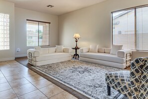 A living room with a beige sofa, a patterned rug, and a lamp. - 5 Mi to Estrella Mtn Park! Home w/ Outdoor Oasis (Goodyear)