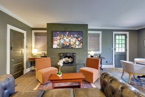 A living room with a fireplace, two armchairs, a sofa, and a coffee table. - Walkable Area! Historic 2-Home Worcester Retreat (Worcester)