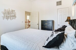 A bedroom with a bed, a dresser, a wall art piece, and a door. - Arlington Home w/ Pool: Just Over 1 Mi to Stadium (Arlington)