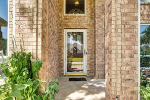 A brick building with a glass door entrance, a small porch, and a window above the door. - Arlington Home w/ Pool: Just Over 1 Mi to Stadium (Arlington)
