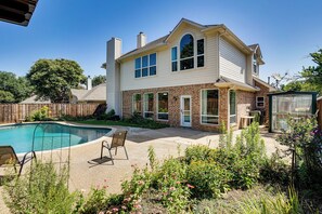 A two-story house with a backyard swimming pool, a patio with chairs, and a garden with various plants. - Arlington Home w/ Pool: Just Over 1 Mi to Stadium (Arlington)