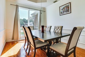 A dining area with a dark wooden table, upholstered chairs, and a view through a large window. - Arlington Home w/ Pool: Just Over 1 Mi to Stadium (Arlington)