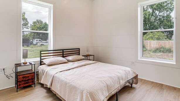 A bedroom with a bed, bedside tables, a lamp, a window, and a view of the outdoors. - Close to Ohio River: 6BR Jeffersonville Home (Jeffersonville)