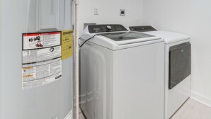 A laundry room with two front-loading washers and dryers, a control panel, and safety instructions on the wall. - Close to Ohio River: 6BR Jeffersonville Home (Jeffersonville)