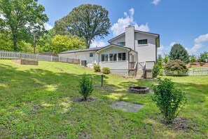 Ein zweigeschossiges Haus mit Veranda, umzäunter Garten und kleinem Gartenbereich.