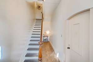 A staircase with a wooden handrail leading to a white door. - Walk to Downtown! Central 2-Apt Combo in Pottstown (Pottstown)