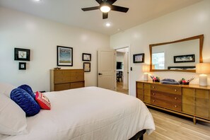 A bedroom with a bed, dresser, and a ceiling fan. - 'The Romano Retreat' Modern Lake Guntersville Home (Scottsboro)