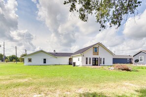 A two-story house with a front porch, a garage, and a large lawn.