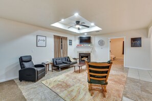 A living room with a sofa, a chair, a fireplace, and a ceiling fan. - Louisiana Group Retreat! Dual Units Near Hunting (Iowa)