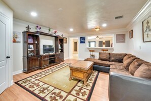 A spacious living room with a large wooden entertainment center, a brown leather sofa, and a patterned rug. - Louisiana Group Retreat! Dual Units Near Hunting (Iowa)