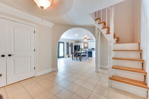 A spacious hallway with a staircase leading to a dining area. - Louisiana Group Retreat! Dual Units Near Hunting (Iowa)