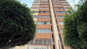 Un edificio de gran altura con un cartel que dice 'URACOA' en la entrada.