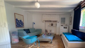 Ein Wohnzimmer mit einer Couch, einem Schaukelstuhl, einem Couchtisch und einem Bett.