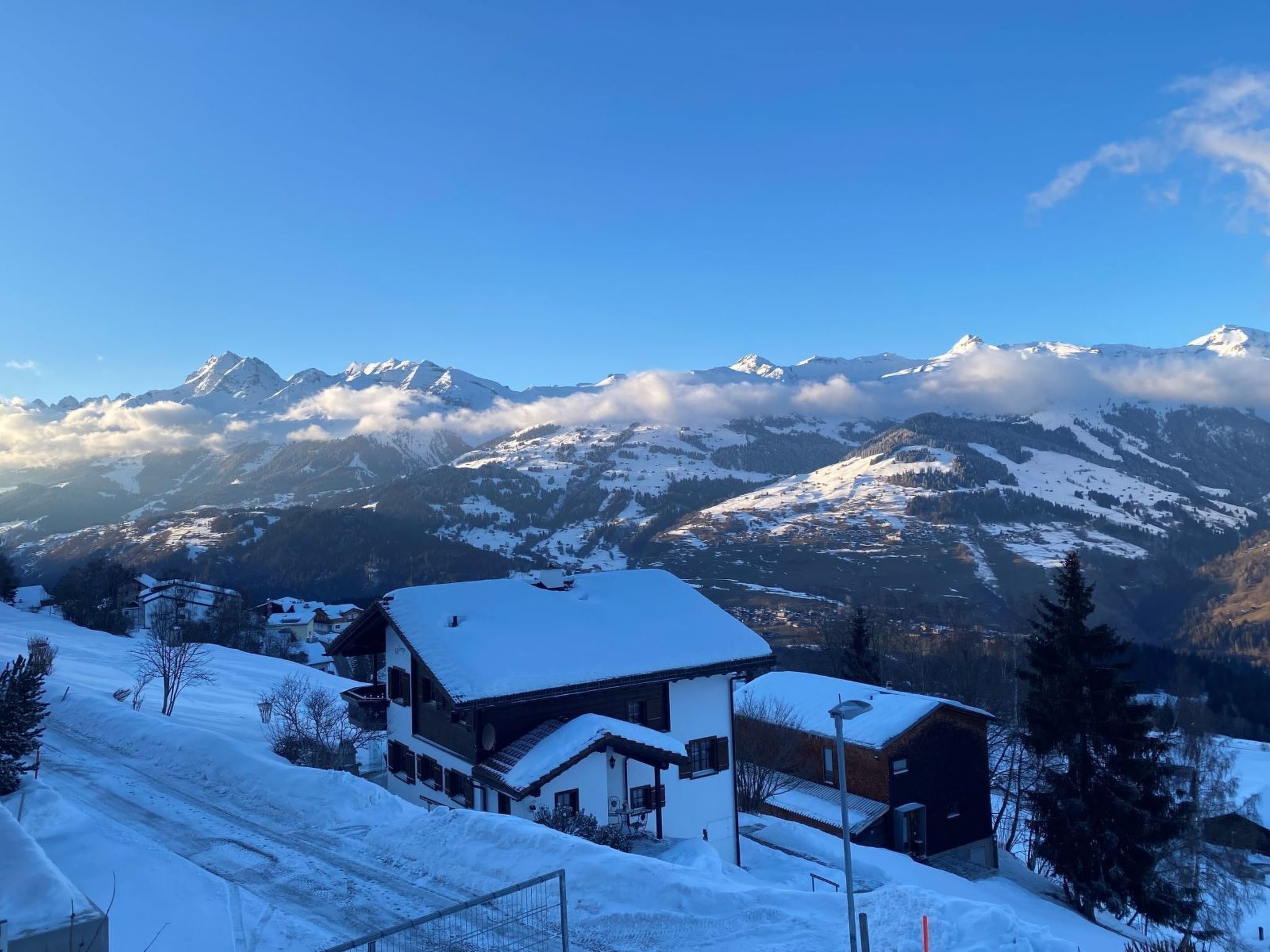 A snow-covered mountain landscape with a house in the foreground.