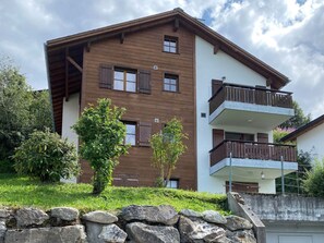 A multi-story building with a wooden facade, multiple windows, and a balcony. - Roda Mulin, Surcuolm, (Surcuolm), 38010B by Interhome (Obersaxen Surcuolm)