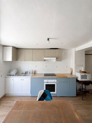 A modern kitchen with a central island, built-in cabinets, and a microwave.