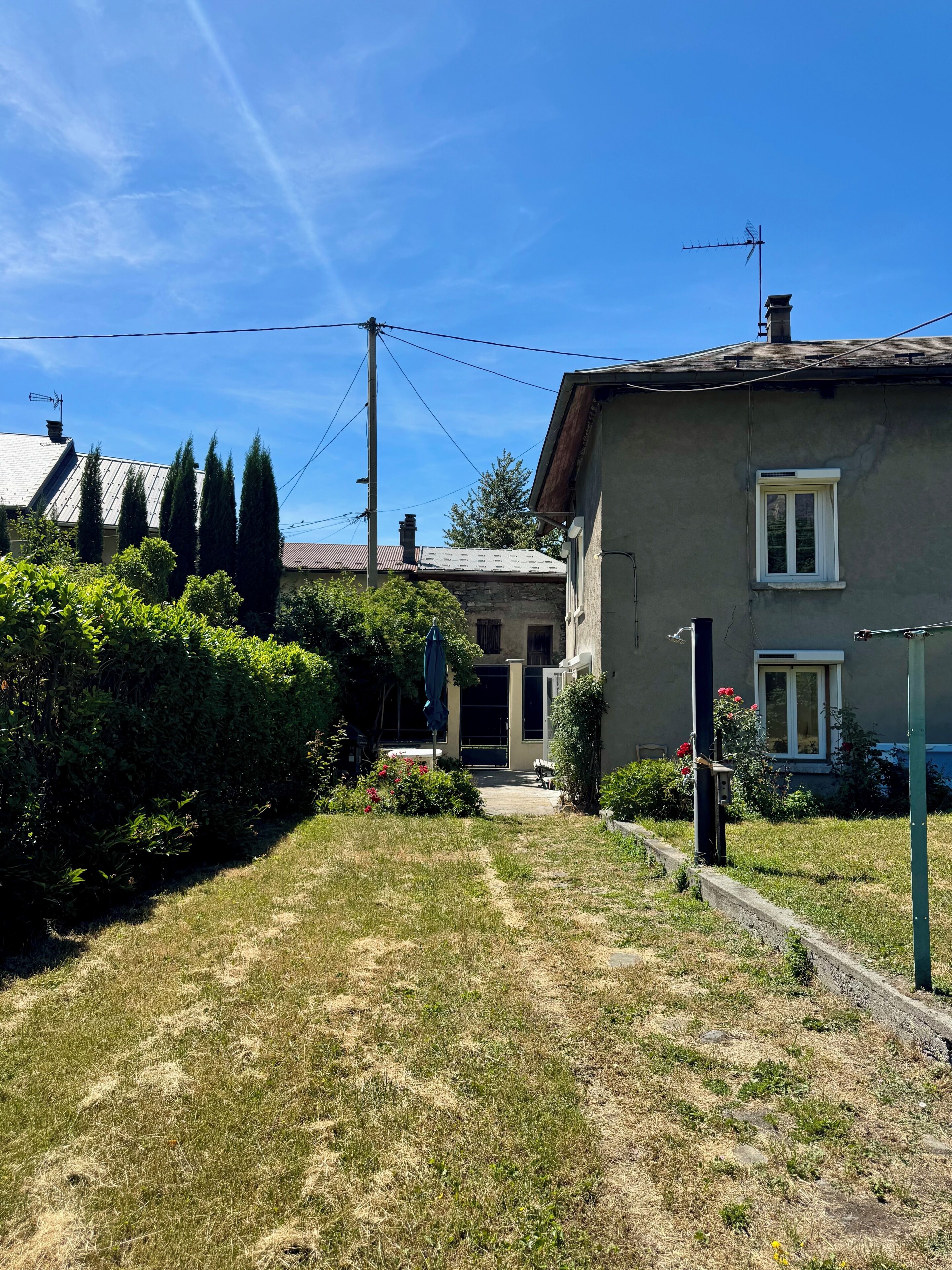 A residential property with a front yard, a pathway leading to the entrance, and a small garden area.