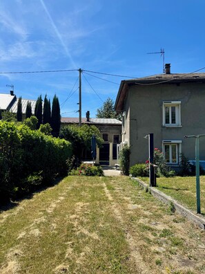 A residential property with a front yard, a pathway leading to the entrance, and a small garden area.